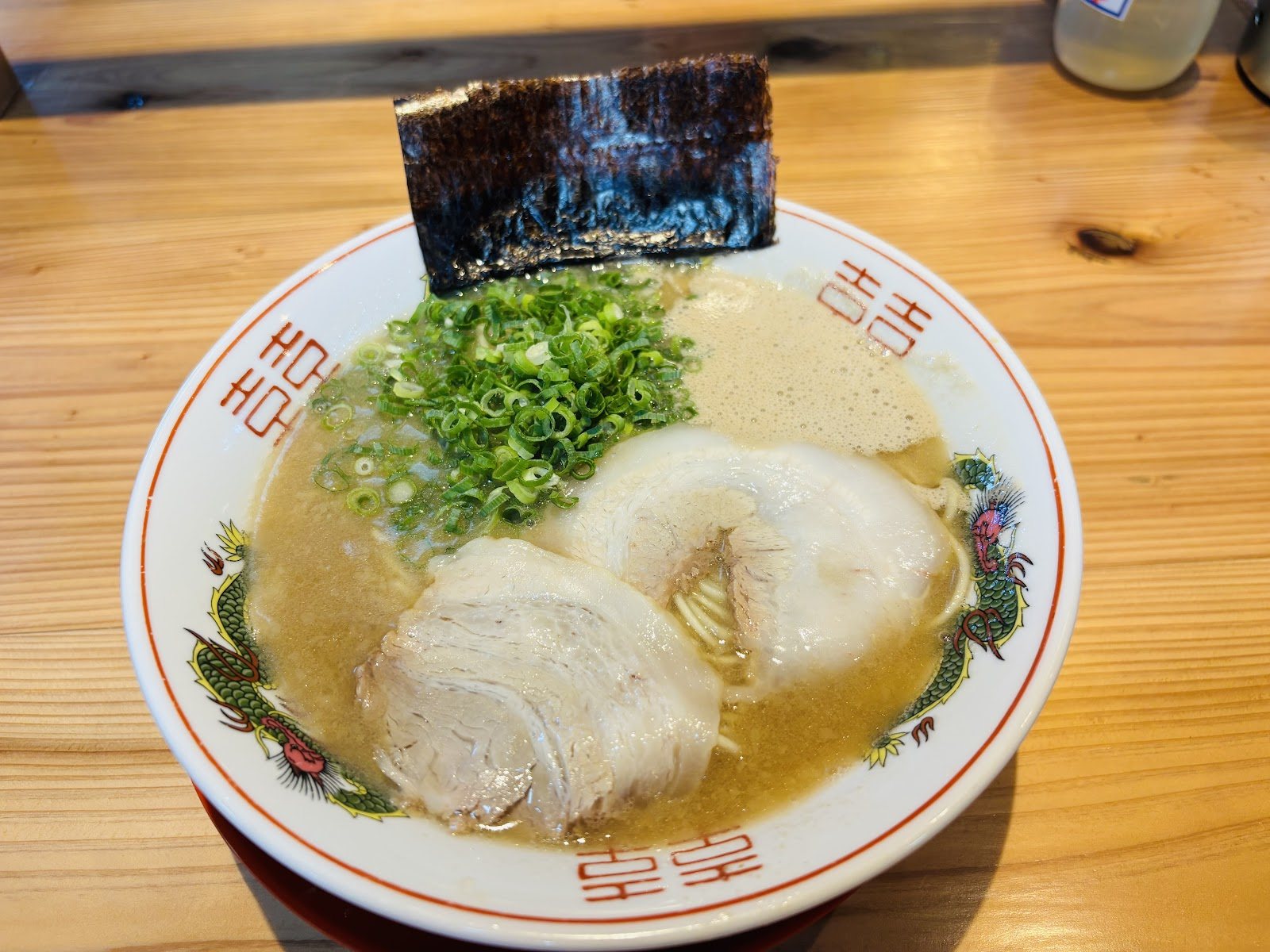 白い丼にチャーシュー、ねぎ、海苔が乗った丸久ラーメン
