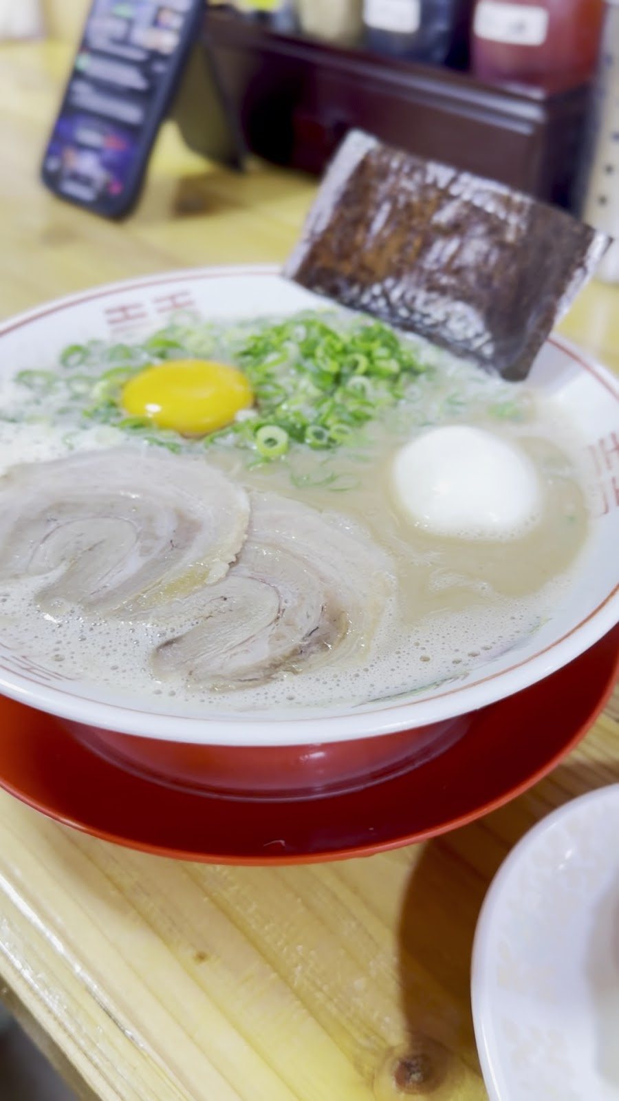 ねぎの上に生卵の黄身が乗ったラーメン