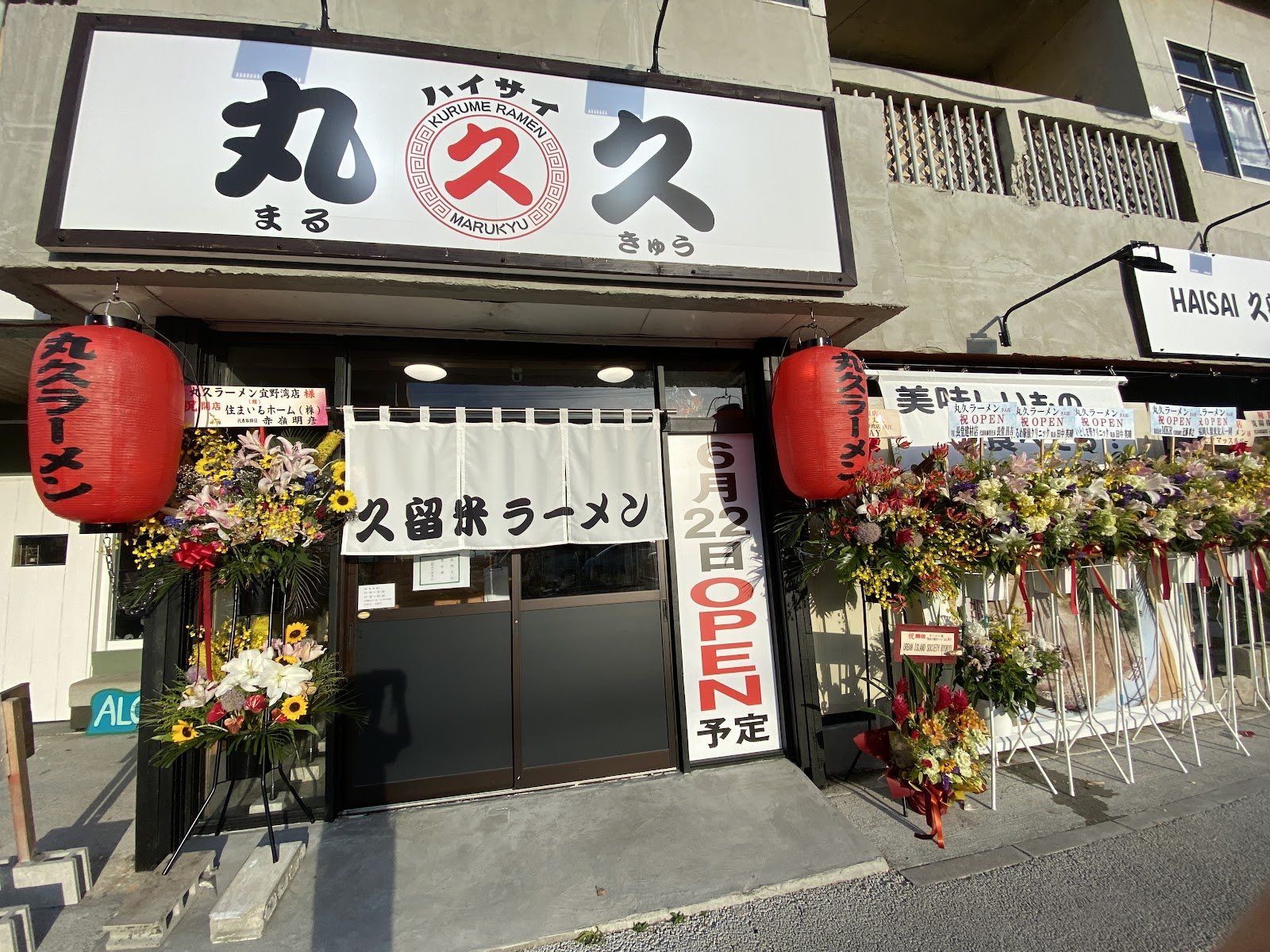 白いのれんと赤提灯の丸久ラーメン宜野湾店の店先
